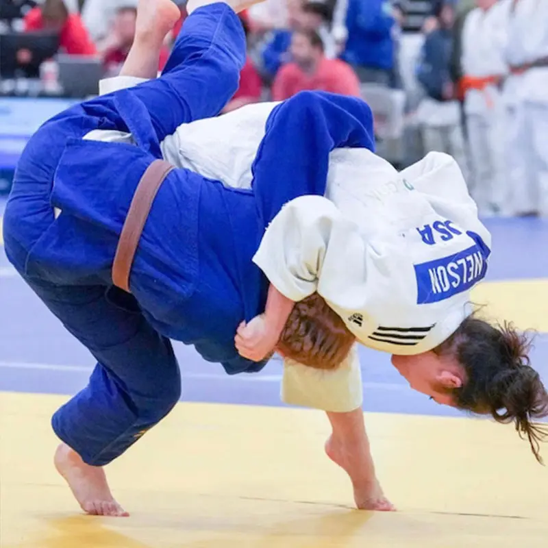 Adult Judo participants kicking pads during stress-relief workout session